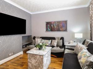 a living room with a couch and a flat screen tv at Walpole House in Great Yarmouth