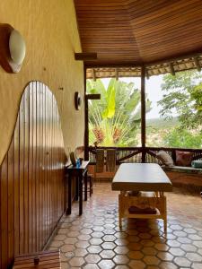 uma sala de estar com uma mesa e uma grande janela em Pousada Vila Serrano em Lençóis