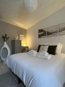 1 dormitorio con 1 cama blanca grande y toallas. en Gîte aux portes d'Angoulême, en Champniers