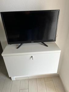 TV de pantalla plana en una cómoda blanca en Isola Rossa Appartamenti Superior, en Isola Rossa