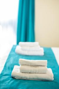four white towels are stacked on a blue table at Casa Armoniei in Baia Mare +101 photos