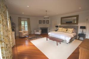 Rushmore Estate في Woodbury: غرفة نوم مع سرير وغرفة معيشة