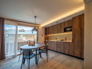 una cucina e una sala da pranzo con tavolo e sedie di Deschana Lodge a Livigno