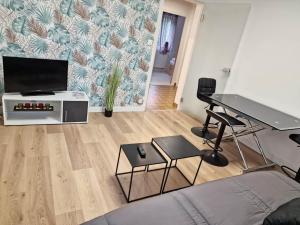 a living room with a table and a television at Maison avec extérieur et arrivée autonome - Aurillac in Aurillac