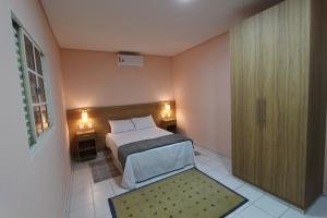 Vida Real Hostel في ساو باولو: غرفة نوم بسرير وباب زجاجي منزلق