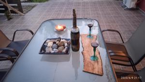 a table with a bottle of wine and a plate of food at HARI'S NEST CORFU in Marathias