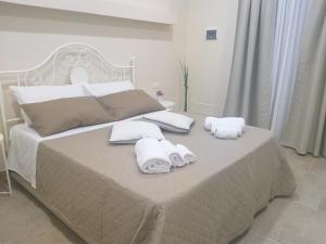 een slaapkamer met een bed met handdoeken erop bij Casetta Porta di Ligne in Catania