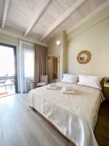 sypialnia z dużym białym łóżkiem w pokoju w obiekcie Gardy rooms w miejscowości Nea Kallikratia