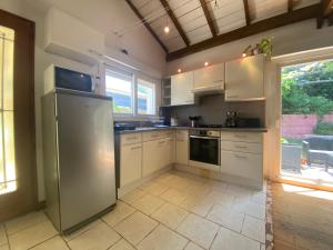 a kitchen with white cabinets and a stainless steel refrigerator at La maison de Mamie in Pessac