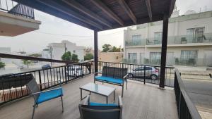 a balcony with chairs and a table and a car on a street at Ayia Napa Cyprus in Paralimni
