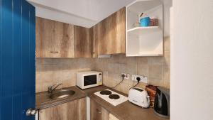 a small kitchen with a sink and a microwave at Ayia Napa Cyprus in Paralimni