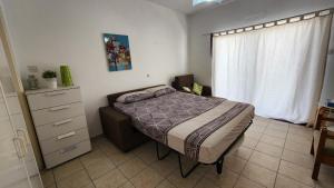a bedroom with a bed and a dresser and a window at Ayia Napa Cyprus in Paralimni