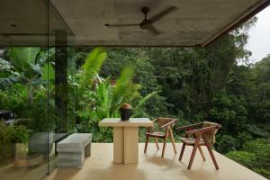 a patio with a table and chairs and trees at ACHIOTÉ Architectural Gem - Adults Only in Uvita