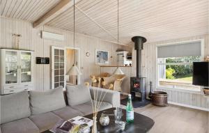 SpodsbjergにあるAwesome Home In Rudkbing With Saunaのリビングルーム(ソファ、薪ストーブ付)