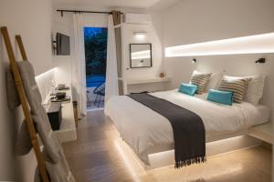 a bedroom with a large bed with blue pillows at SEAMENTO suites in Tinos Town