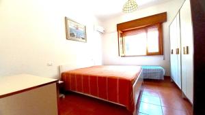 mały pokój z łóżkiem i oknem w obiekcie Villa Montedarena w mieście Pulsano
