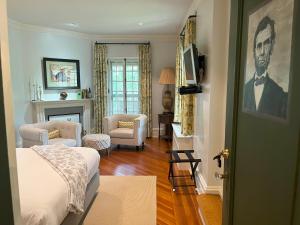 Rushmore Estate في Woodbury: غرفة معيشة مع سرير ومدفأة
