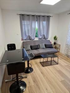 uma sala de estar com um sofá e uma mesa em Maison avec extérieur et arrivée autonome - Aurillac em Aurillac