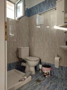 La salle de bains est pourvue de toilettes, d'une baignoire et d'un lavabo. dans l'établissement Sunset Apartments, à Kanali