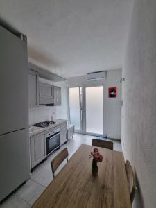 a kitchen with a wooden table and chairs in a room at Mito apartment in Cagliari