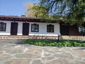 a house with a stone patio in front of it at Фильовата къща in Zheravna