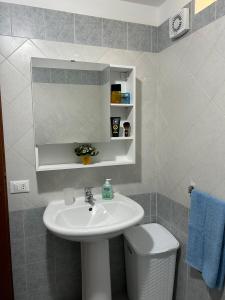 Villetta sul mare in Resort Village في كامبوفيليتْشّي دي روتْشّيلا: حمام مع حوض ومرحاض ومرآة