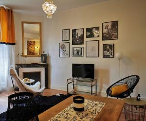 uma sala de estar com uma mesa e uma televisão em BELLE REINE - 3 APPARTEMENTS EN COEUR DE CENTRE-VILLE em Aix-les-Bains