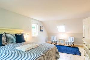 een slaapkamer met een bed met een blauw tapijt en 2 stoelen bij Beautiful Home Easy Access to Beaches in Brewster