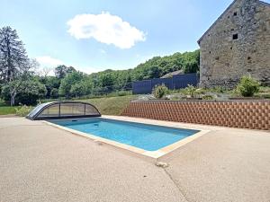 a swimming pool in a yard with a brick wall at Le Domaine de la Forge - 12 personnes in Saint-Yrieix-les-Bois