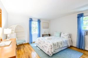 - une chambre blanche avec un lit et des rideaux bleus dans l'établissement Close to Bayside Game Room w Pool Table, à Brewster