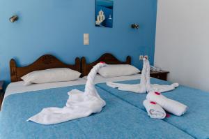 twee bedden met witte handdoeken bovenop bij Anatoli Beach Hotel in Georgioupolis