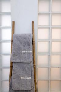 a towel rack with two towels on it next to shelves at SEAMENTO suites in Tinos