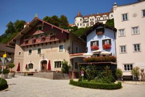a building with flowers in the courtyard of a town at Hotel Hofwirt Neubeuern in Neubeuern