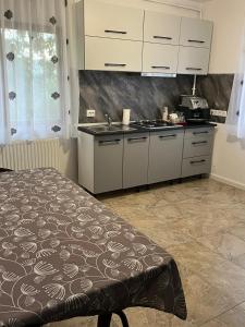 uma cozinha com armários brancos e uma cama num quarto em Casa Luna em Cluj-Napoca
