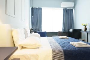 a hotel room with a bed with towels on it at Sani Deluxe Suites - Monastiraki Square - Brand New in Athens
