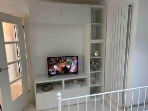 een woonkamer met een flatscreen-tv op een plank bij Chetwynd Paradise in Londen