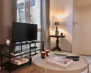 a living room with a tv and a coffee table at Le Patio, Climatisation Terrasse Wi-Fi Netflix 15 mn coeur de ville in Béziers