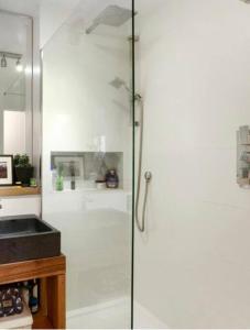 a shower with a glass door in a bathroom at Chetwynd Paradise in London