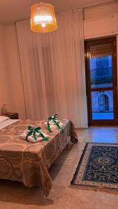 ein Schlafzimmer mit einem Bett mit grünen Bögen darauf in der Unterkunft Apulia appartament in Taranto