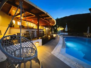 a patio with a swing next to a swimming pool at Spitaki Guest House in Megali Ammos