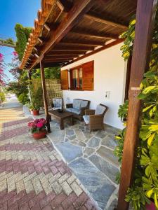 a patio with a table and chairs under a pergola at Spitaki Guest House in Megali Ammos