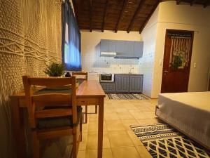 a kitchen with a table and chairs and a bed at Spitaki Guest House in Megali Ammos
