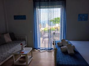 un soggiorno con letto e una grande finestra di Thalassa Apartments & Studios a Kávos