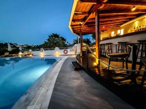 a swimming pool at night with a house and a building at Spitaki Guest House in Megali Ammos