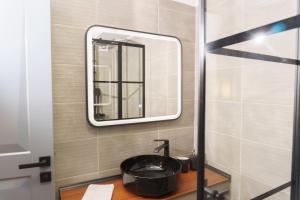 a bathroom with a sink and a mirror at Sani Deluxe Suites - Monastiraki Square - Brand New in Athens
