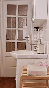 a white bathroom with a sink and a mirror at Ammos studio Loutraki in Loutraki