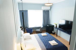 a hotel room with a bed and a television at Sani Deluxe Suites - Monastiraki Square - Brand New in Athens