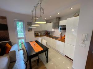 a kitchen and dining room with a table and a couch at Apartament Marcin in Międzywodzie