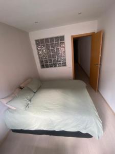 a bedroom with a large white bed with a window at Cozy apartment at a great location! in Hospitalet de Llobregat