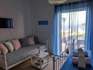 カボスにあるThalassa Apartments & Studiosのソファと大きな窓のあるリビングルーム